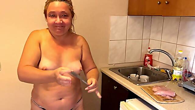 Zara prepares a meal topless in the kitchen